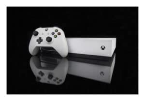 Xbox - Consola blanca con control reflejado en un fondo negro
